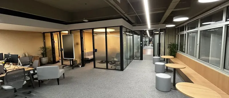 Ambiente corporativo entregue no escritório Serena, com salas de reunião e estações de trabalho